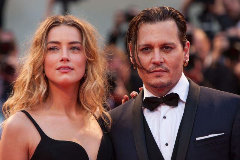   Amber Heard e Johnny Depp vistos em uma cerimônia.