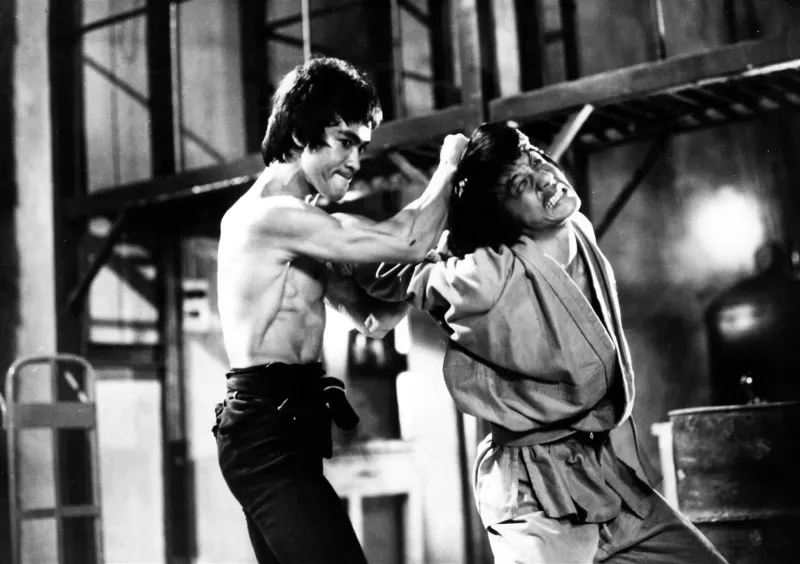   Jackie Chan en wijlen Bruce Lee in een still uit Enter the Dragon (1973)