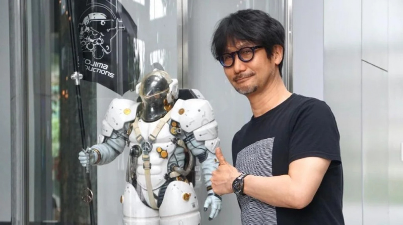   Hideo Kojima poserer ved siden av en romdrakt