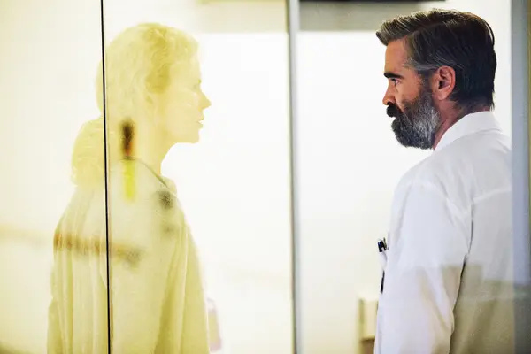   Colinas Farrellas žiūri į Nicole Kidman pro stiklą